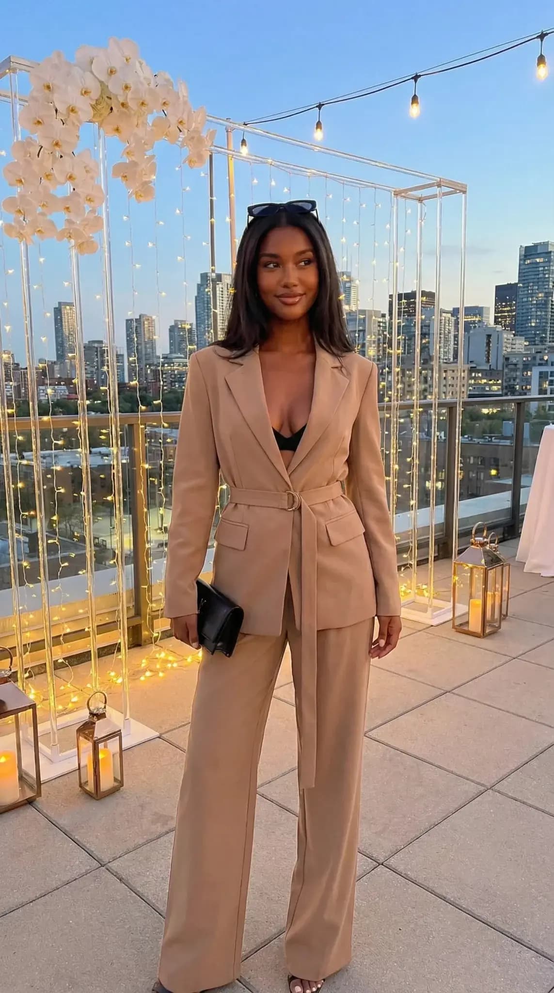 Tan belted blazer suit with wide-leg pants at rooftop city skyline venue